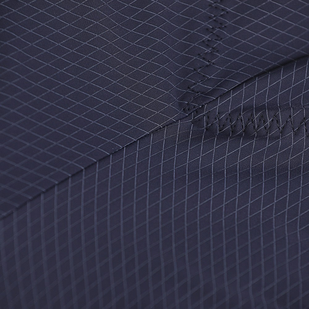 Close-up of a navy blue fabric with a subtle pattern and stitching detail.